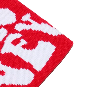 Macro shot of red and white jacquard knit fabric with detailed stitching and letter pattern