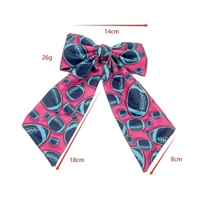 Pink Super Bowl hair bow with blue football pattern and 14cm dimensions on white background