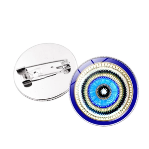 Detail showing front blue evil eye design and silver metal pin back on white background