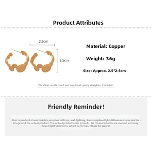Detailed view of golden irregular C-shaped earrings with textured metal surface