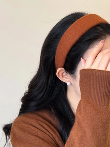Primo piano di un'ampia fascia per capelli in peluche marrone scuro per la moda autunno inverno