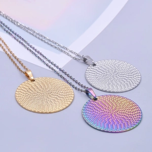 Three textured round stainless steel pendants in gold, silver, and rainbow on chains