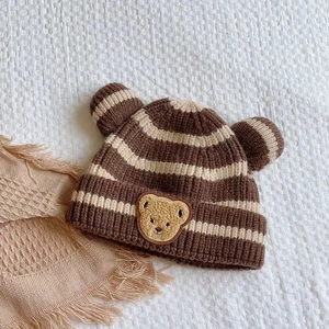 Détails de la maille du bonnet rayé pour bébé avec oreilles 3D et écusson d'ours