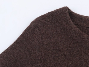 Detail view of the brown knit dress showing plush shoulder seams and fabric texture