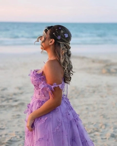 Detail of purple tulle wedding dress featuring 3D butterfly appliqués and lace flowers