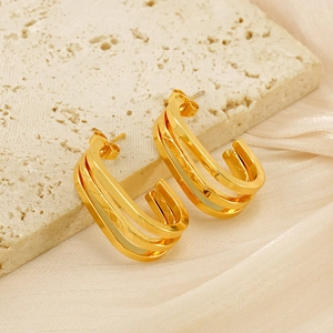 Dettaglio macro di orecchini a cerchio triplo in oro 18K con incisione a rombi