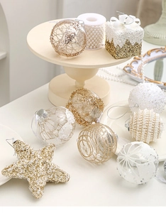 Detail of white and gold Christmas ornaments including beaded spheres and a golden starfish