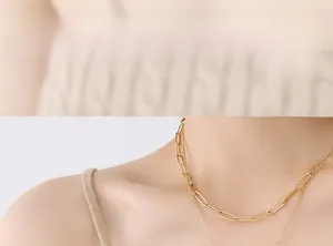 Close-up of model wearing double-layered 18K gold-plated paperclip and fine chain necklace