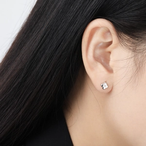 Elegant silver four-leaf flower stud earrings with sparkling diamonds on female model