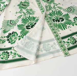 Detailed view of dark green vintage floral print on lightweight cream dress fabric