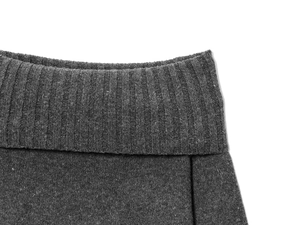 Close-up of charcoal gray knit fabric showing the detailed ribbed texture and quality fold