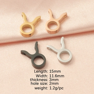 Taurus zodiac charms in gold, rose gold, silver and black finishes on pink silk
