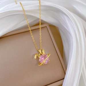 Pink rabbit ear pendant necklace in gold finish with sparkling crystals on silk background