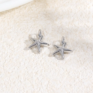 Macro shot of a pair of silver starfish charms made of copper for DIY jewelry making