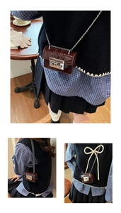 Three-way view of a dark burgundy litchi texture mini crossbody bag with silver chain