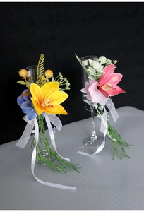 Close-up of artificial cymbidium flowers with silk ribbons and pearls for wedding glasses