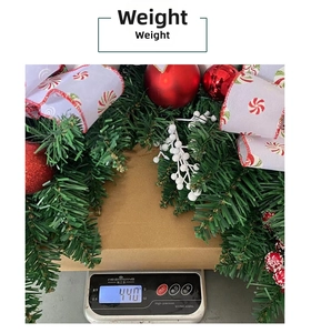 Detailed view of a Christmas garland with red ornaments and white berries on a scale weighing 440g