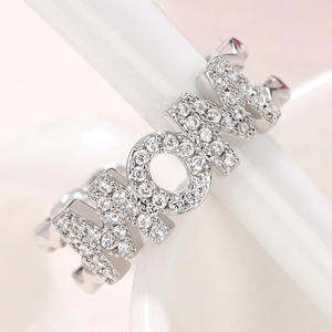 Close-up of MOM letter ring with micro-pave zircons and geometric textured band