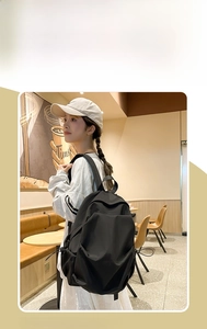 Detail of a large black waterproof nylon backpack with side pockets and zipper closure
