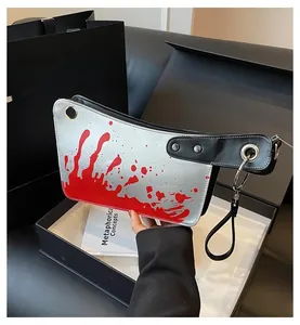 Detailed close-up of a meat cleaver-shaped crossbody bag with realistic blood splatter print