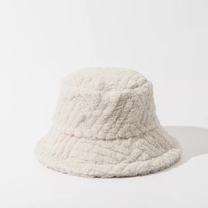 Close-up of the plush texture and soft off-white lamb wool fabric on a fisherman hat