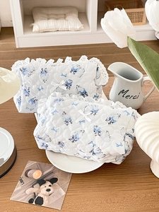 Detail of floral quilted cosmetic bag set featuring lace trim and blue cat patterns