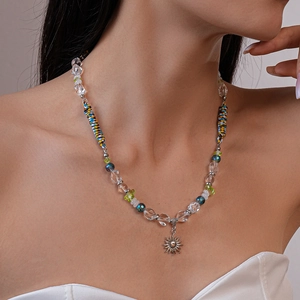Détail du collier pendentif soleil avec perles colorées et corde bohème sur un modèle