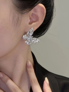 Close-up of a model wearing a sparkling silver zircon butterfly stud earring