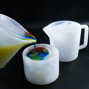 Detailed macro view of 5-grid silicone mixing cup pouring multi-colored resin into mold