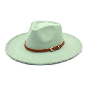 Dettaglio cappello fedora verde menta a tesa larga con fascia in pelle marrone e fibbia oro