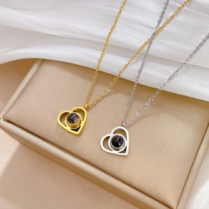 Detailed view of heart projection pendant necklaces in gold and silver on silk