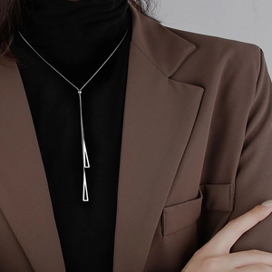 Minimalist silver double triangle pendant necklace for women shown on a model