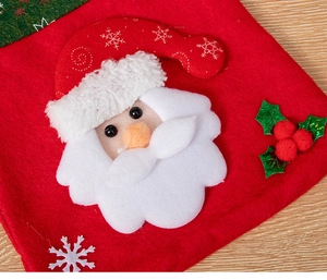 Close-up of red felt Christmas gift bag featuring Santa Claus and embroidered snowflakes
