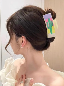 Detail view of a leather western hair claw clip featuring a cactus desert pattern on model