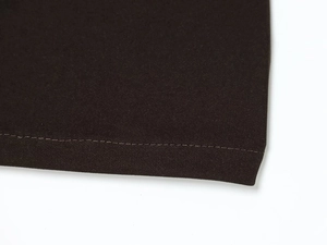 Vista macro dettagliata della trama del tessuto twill marrone scuro e dell'orlo cucito