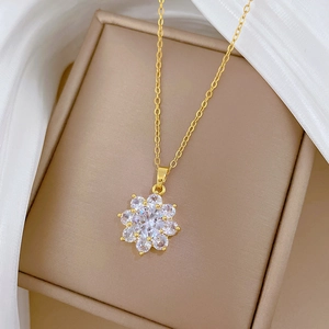 Detailed macro view of a gold flower necklace with zircon crystals on silk fabric
