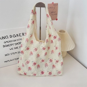 Detailed close-up of floral lace embroidery and pink flower print on a canvas tote bag