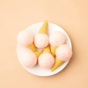 Pink wool felt ice cream ornaments for Christmas tree decoration in white ceramic plate