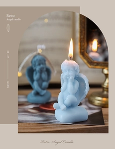 Detailed view of a burning retro blue angel-shaped soy candle on vintage props