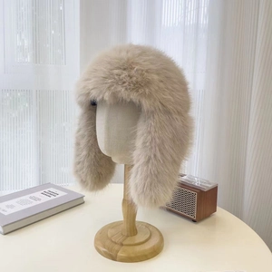 Dettaglio della morbida pelliccia sintetica beige di un cappello invernale con paraorecchie