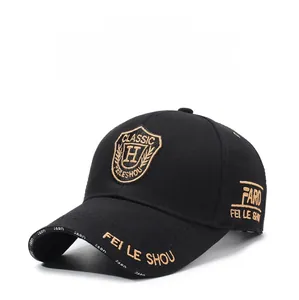 Detailed view of golden embroidery and shield patch on a black cotton baseball cap