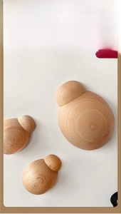 Set of three wooden ladybug magnetic bottle openers with natural grain on white surface