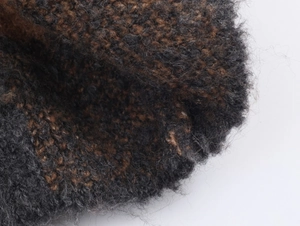 Close-up of thick knit plaid coat fabric showing grey brown melange texture and soft wool fibers