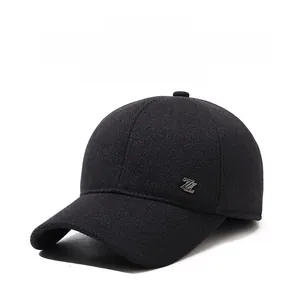 Detail of winter baseball cap with ear protection flaps and metal logo on textured fabric