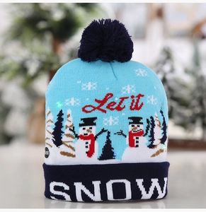 Détail du bonnet de Noël LED bleu ciel avec texte Let it Snow et pompon bleu