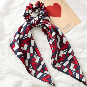 Detail of satin ponytail scrunchie with red, white, and navy geometric pattern