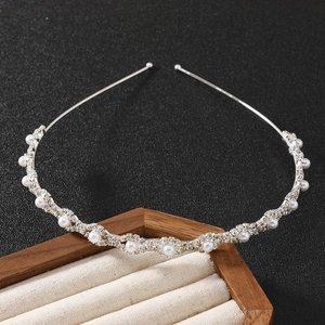 Sparkling silver headband with pearls and rhinestones on beige jewelry display