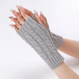 Detail of grey cable-knit fingerless gloves showing soft texture and arm sleeve pattern