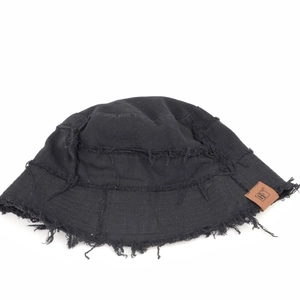 Detailed view of black canvas bucket hat featuring frayed edges and brown leather logo patch