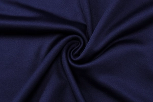 Vue macro détaillée de la texture en maille bleu foncé et de l'élégant drapé plissé